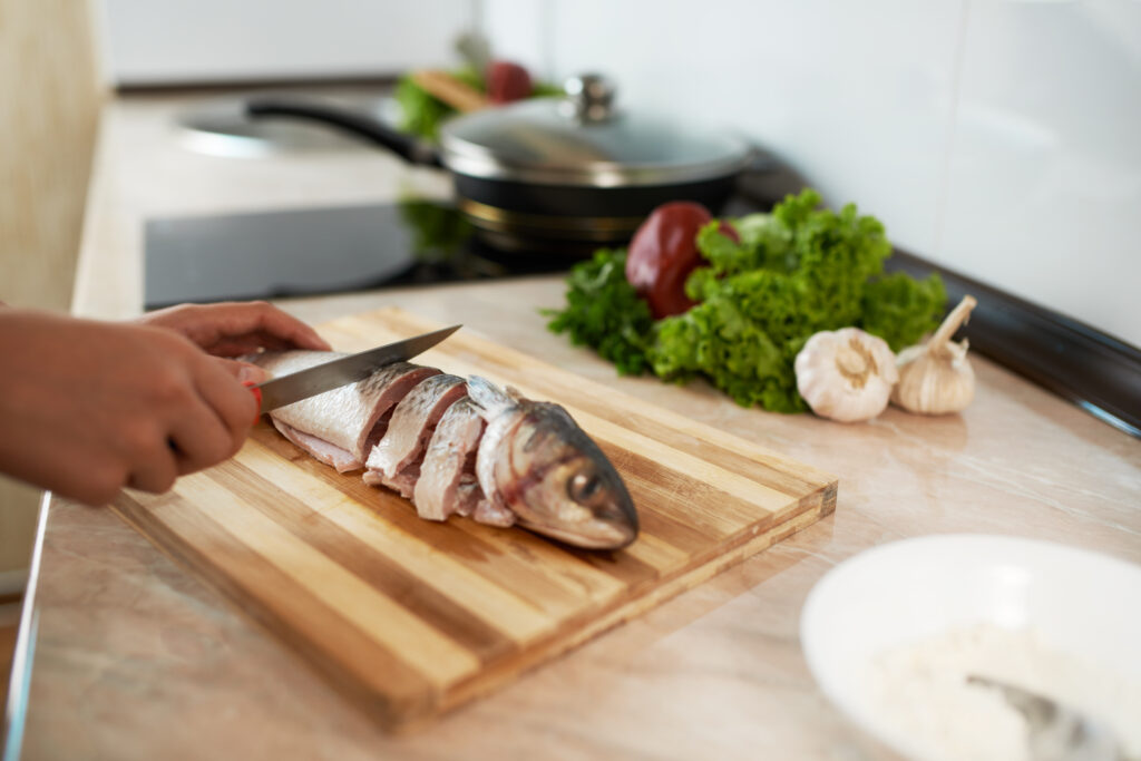 Preparing seafood in a home kitchen after choosing to buy seafood online in Singapore