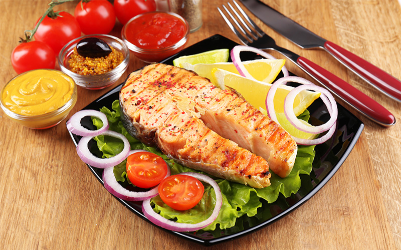 Grilled salmon steak served with fresh vegetables for family nutrition.