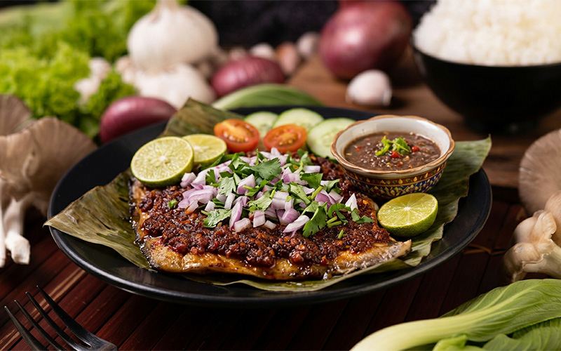 Traditional grilled sambal stingray served on a banana leaf.