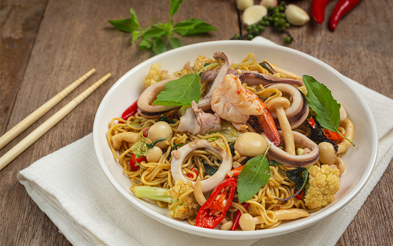 Stir-fried noodles with shrimp, squid, and fresh basil.
