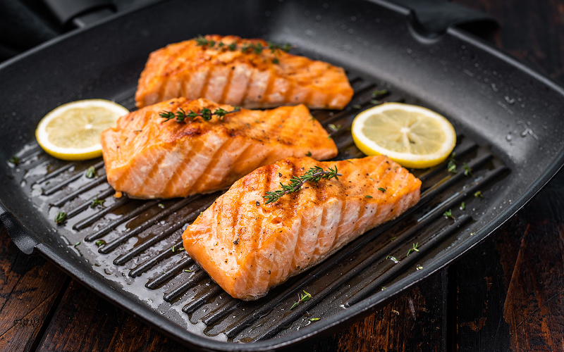 Pan-seared-salmon-fillets-with-lemon-slices-in-grill-pan
